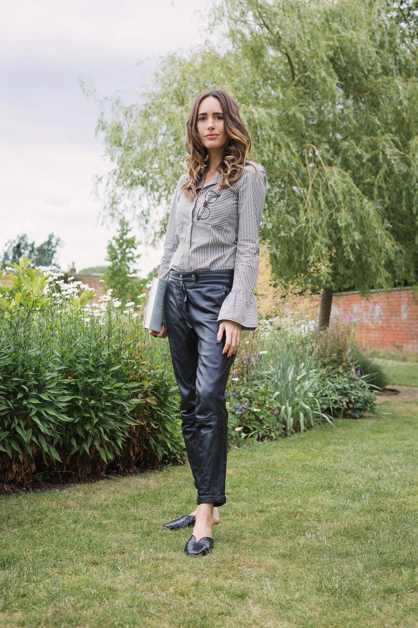 Louise Roe showcases a chic work outfit featuring leather pants and a striped blouse
