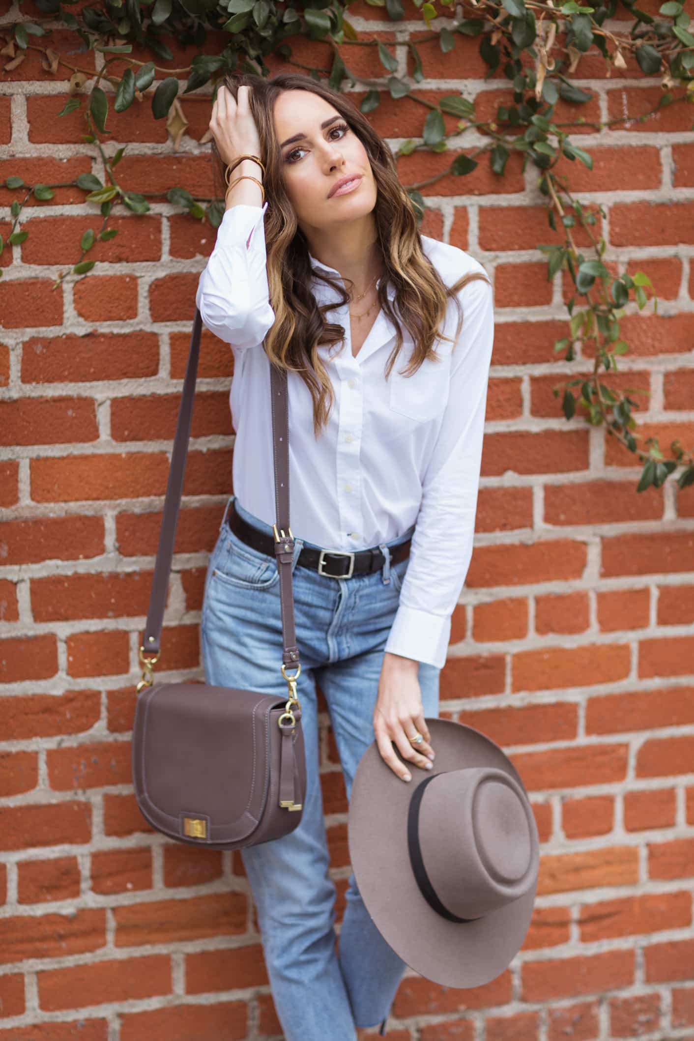 Louise Roe wearing Brahmin crossbody bag with jeans and white