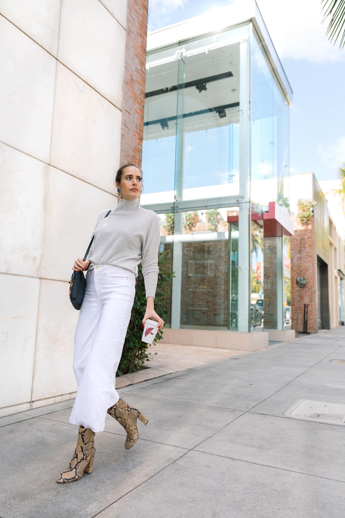 Louise Roe wearing spring denim trends with white jeans and snakeskin boots