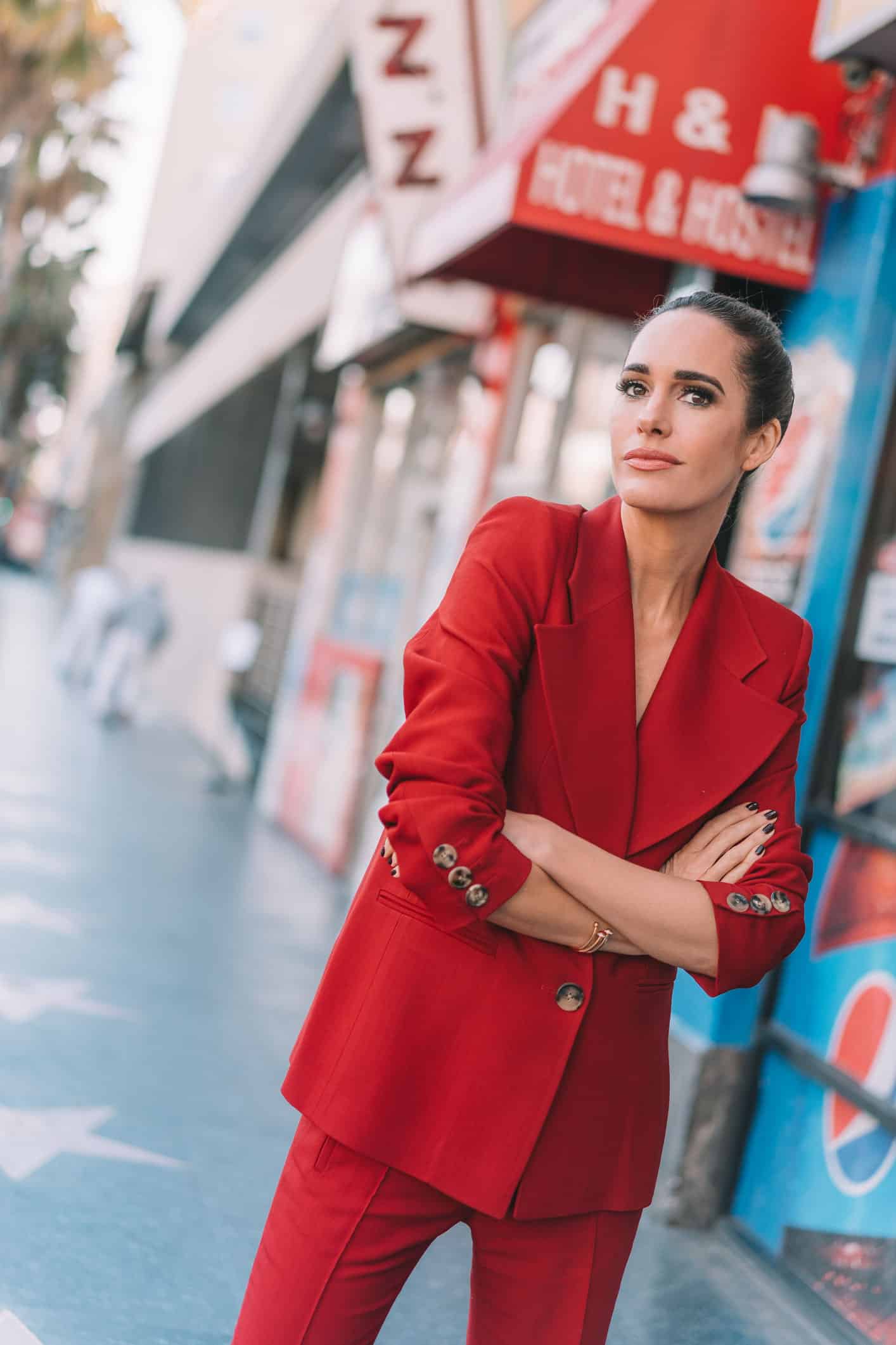 Louise Roe wearing a bold red power suit by Khaite