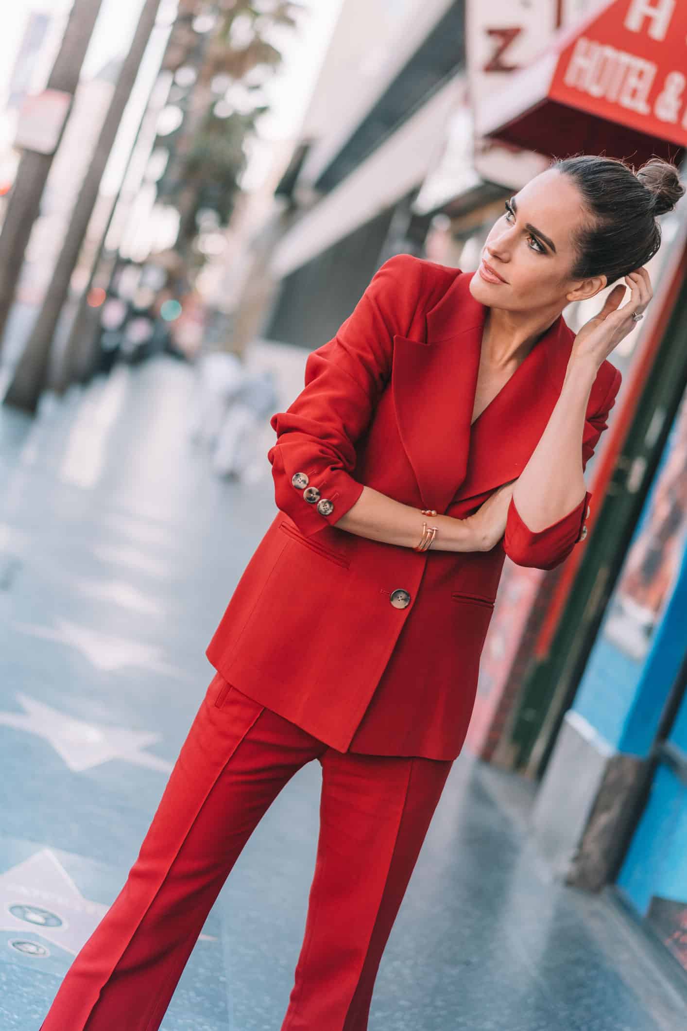 Louise Roe wearing a bold red power suit by Khaite