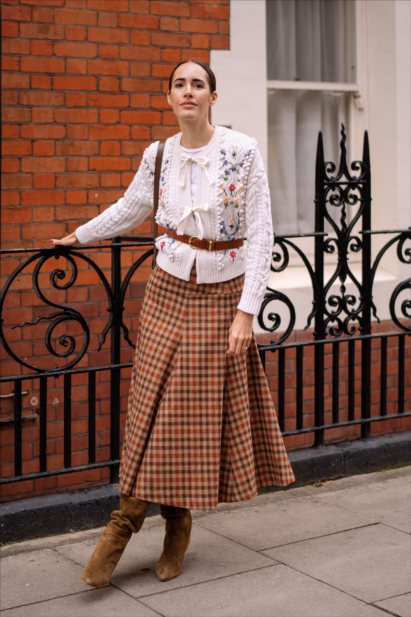 Louise wearing an embroidered cardi and a plaid midi skirt